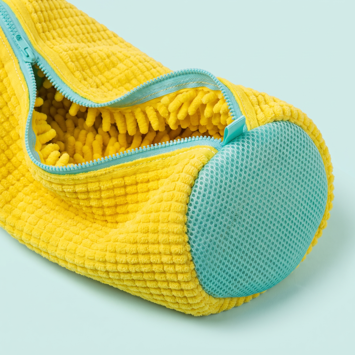 Détail des microfibres jaunes, du filet et de la fermeture turquoise du sac de lavage